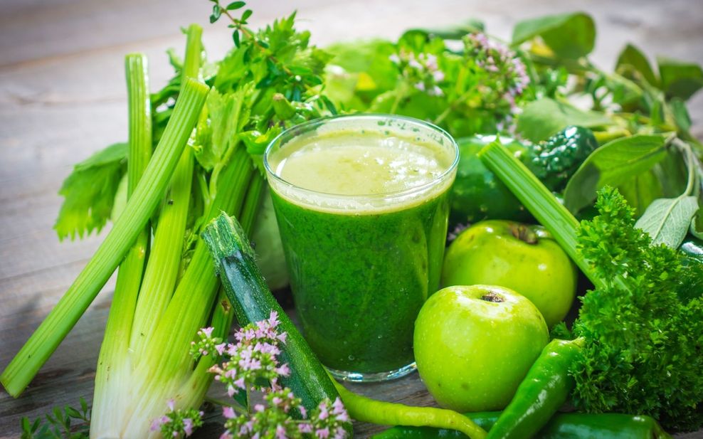 Kozarec svežega zelenega soka na leseni podlagi z zeleno zelenjavo in sadjem
